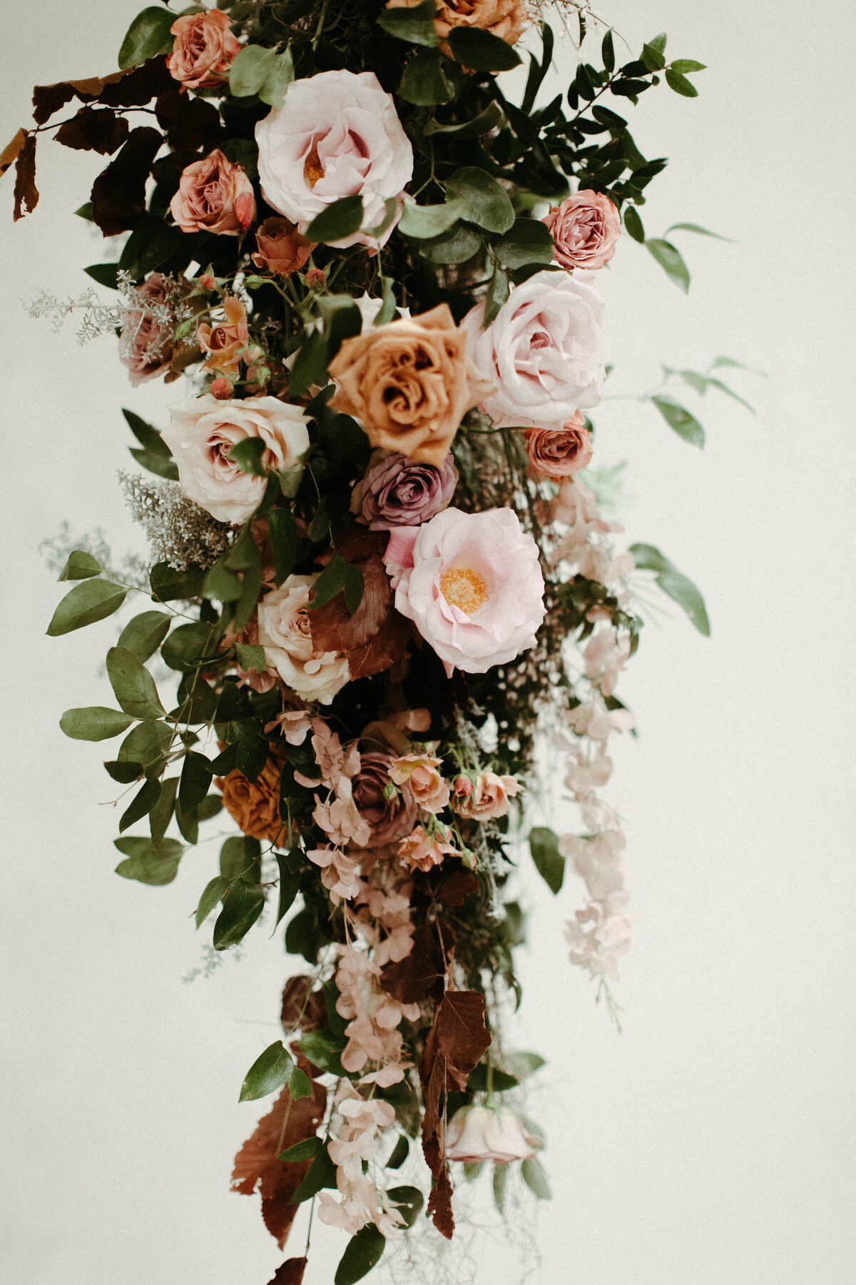 An eye-catching whimsical installation full of petal heavy roses and copper beech was the highlight of this art deco wedding. Terra cotta, burgundy, dusty pink, and other neutral florals warm up this ceremony. Designed by Rosemary and Finch in Nashville, TN.An eye-catching whimsical installation full of petal heavy roses and copper beech was the highlight of this art deco wedding. Terra cotta, burgundy, dusty pink, and other neutral florals warm up this ceremony. Designed by Rosemary and Finch in Nashville, TN.