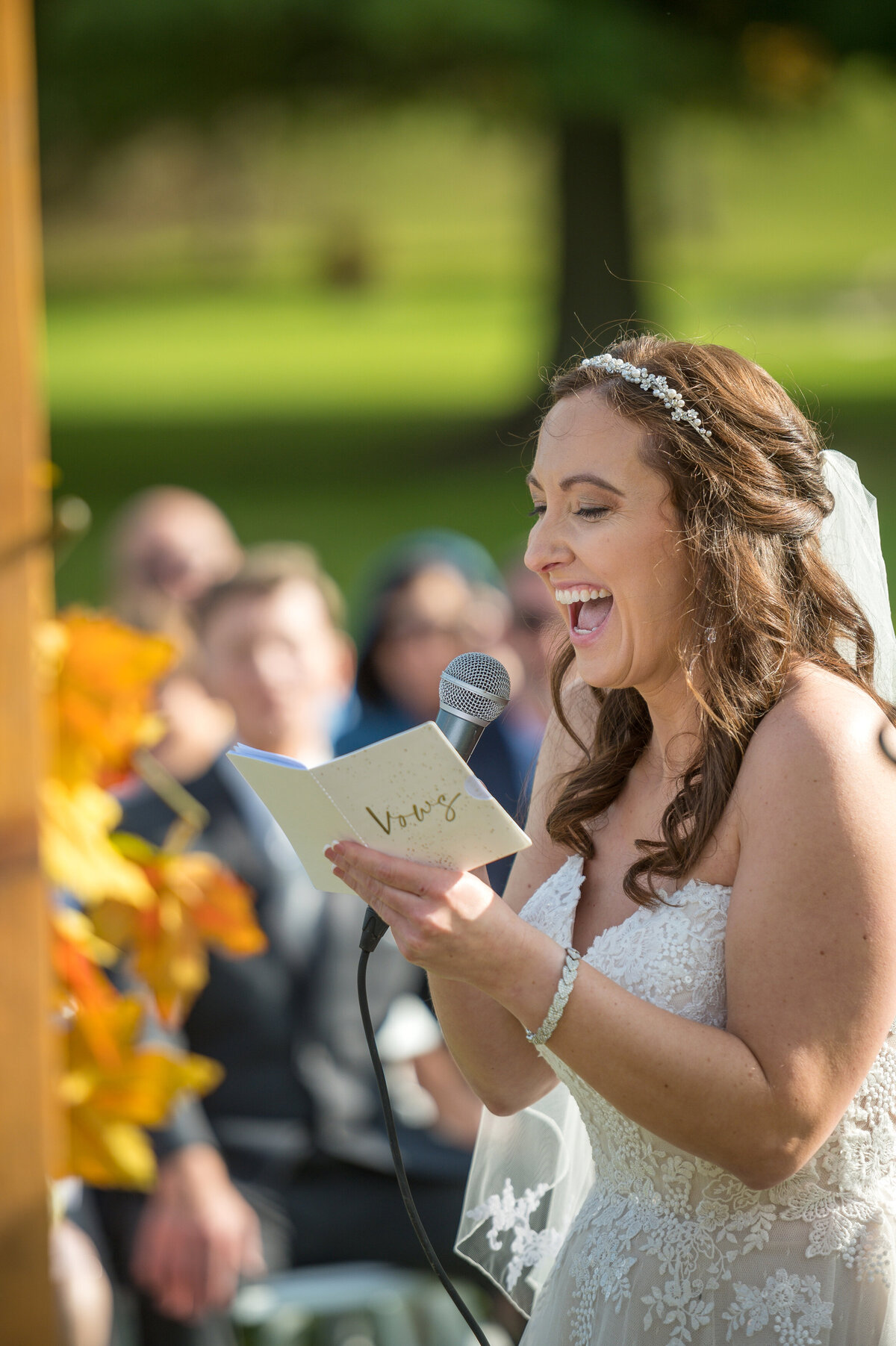 Bride reading vows during outdoor wedding ceremony.