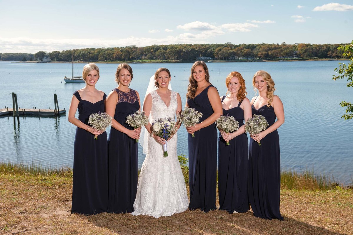 Bride and bridesmaids by the water at The Ram's Head Inn