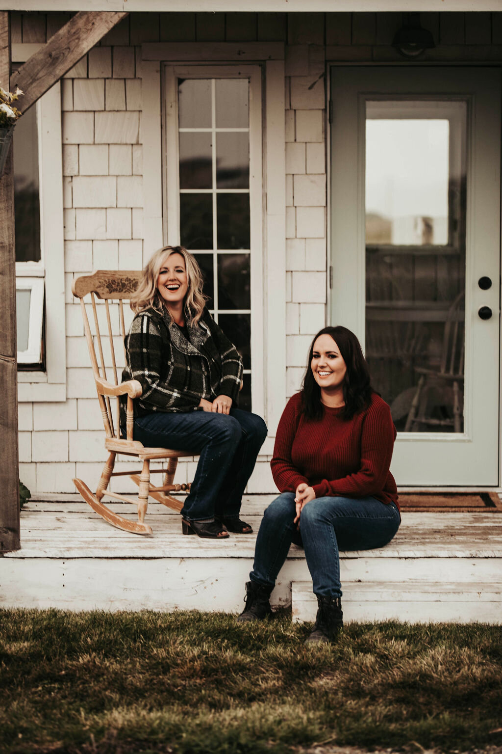 two women sitting on a porch