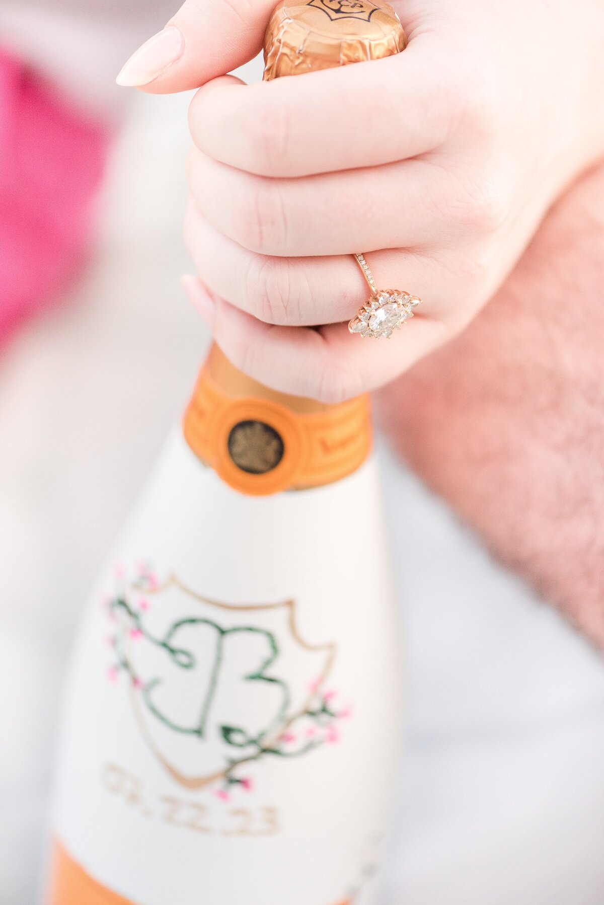 close up of engagement ring on custom champagne bottle