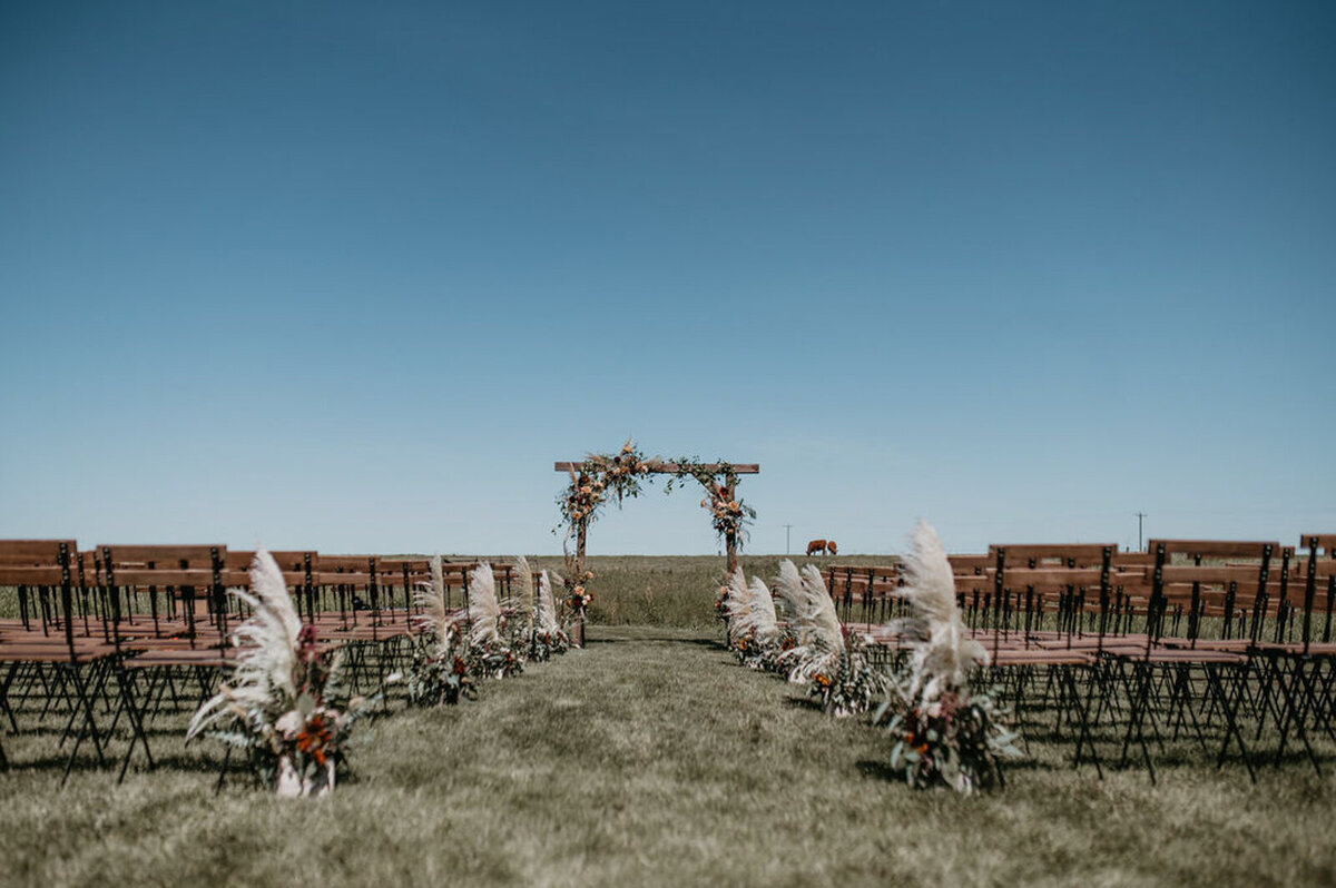 Beautiful outdoor ceremony at The Gathered, a nostalgic greenhouse based in Kathryn, Alberta wedding venue, featured on the Brontë Bride Vendor Guide.
