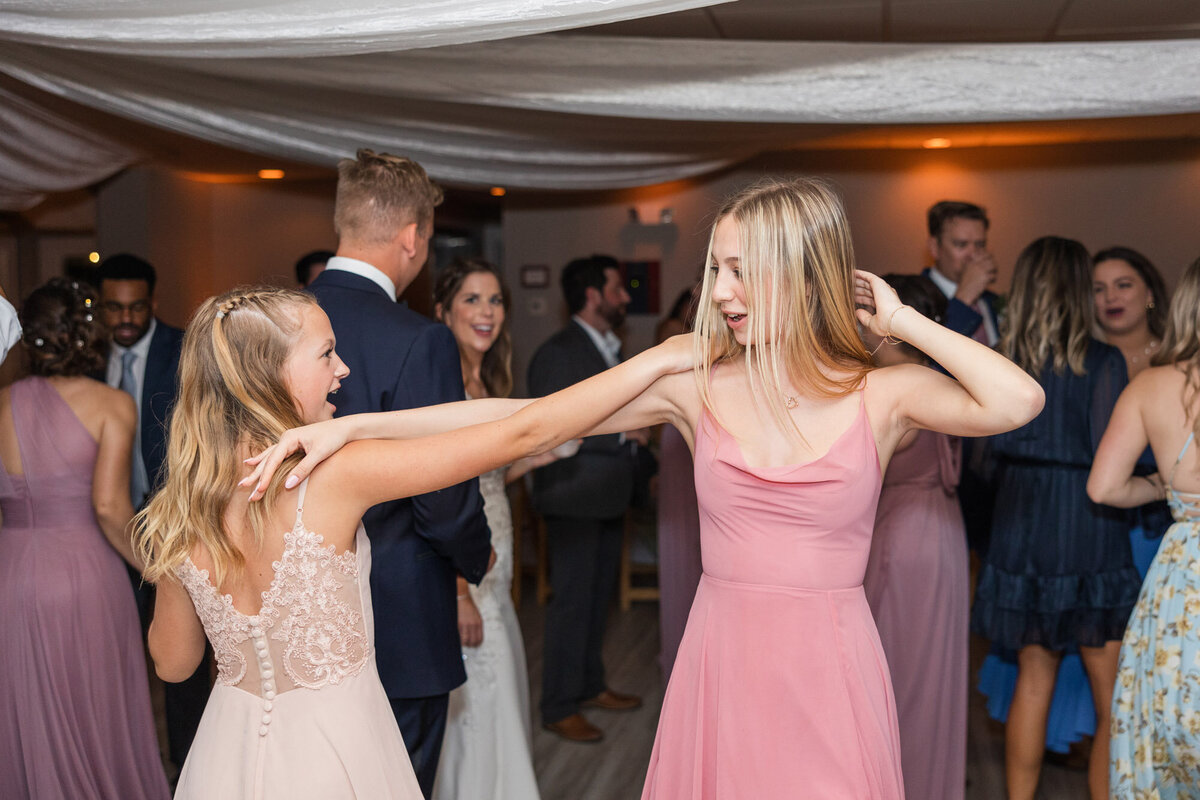 two young girls dancing at a wedding reception