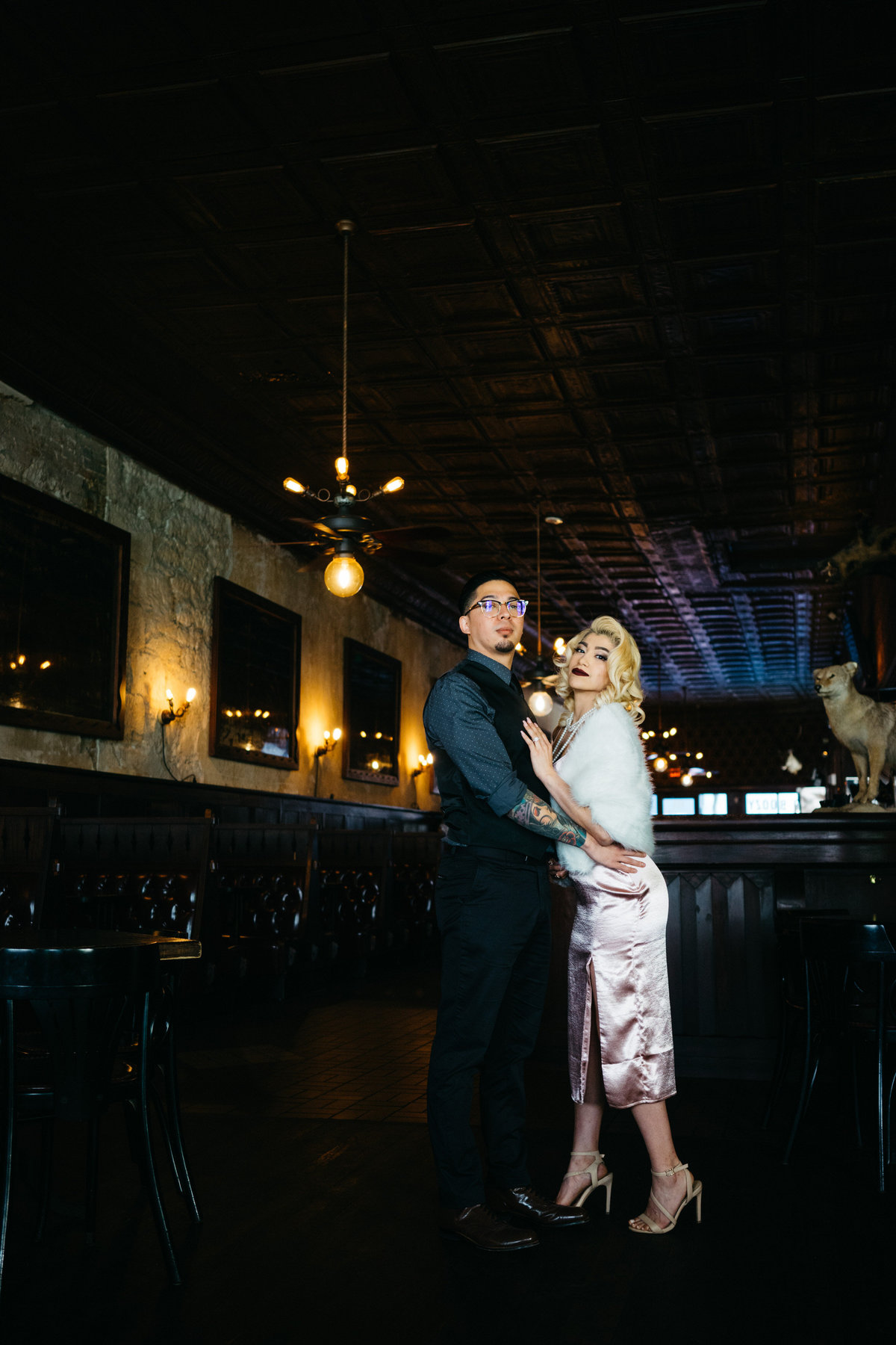 Couple posing for a picture for their engagement session at a bar in downtown San Antonio.