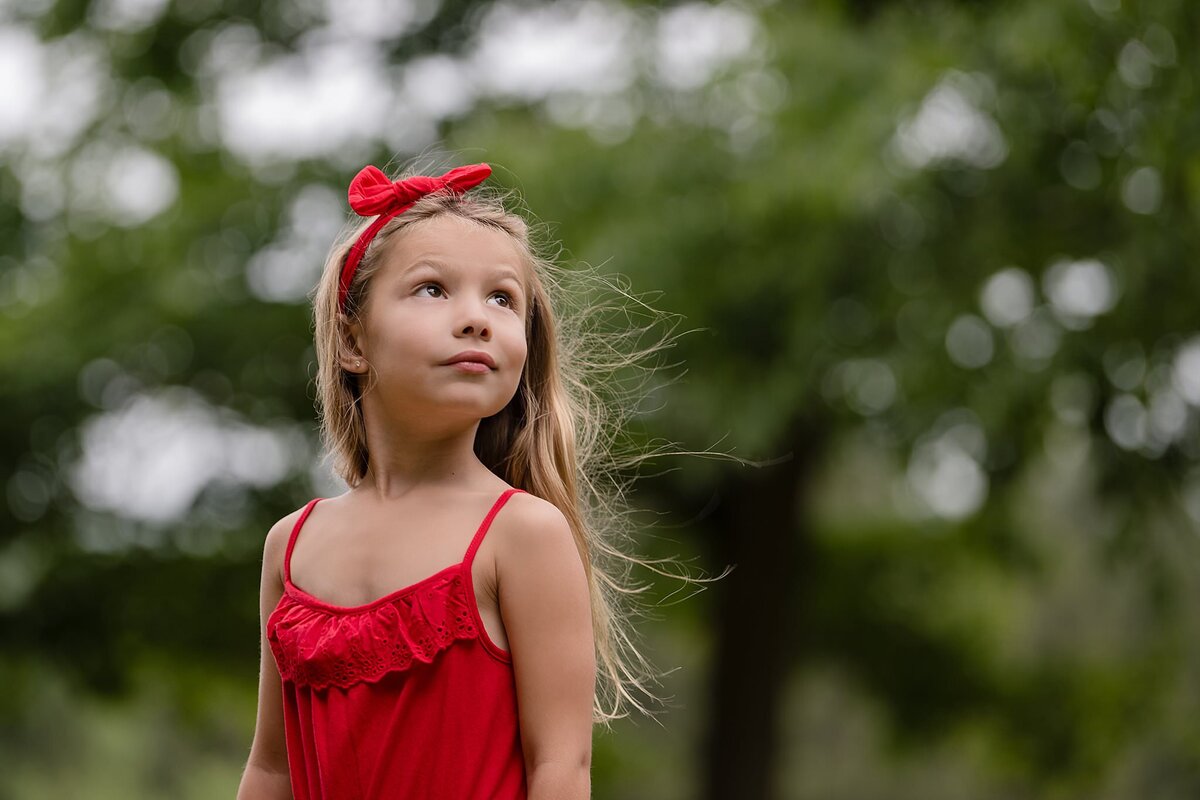 girl in red dress with hair blowing in wind