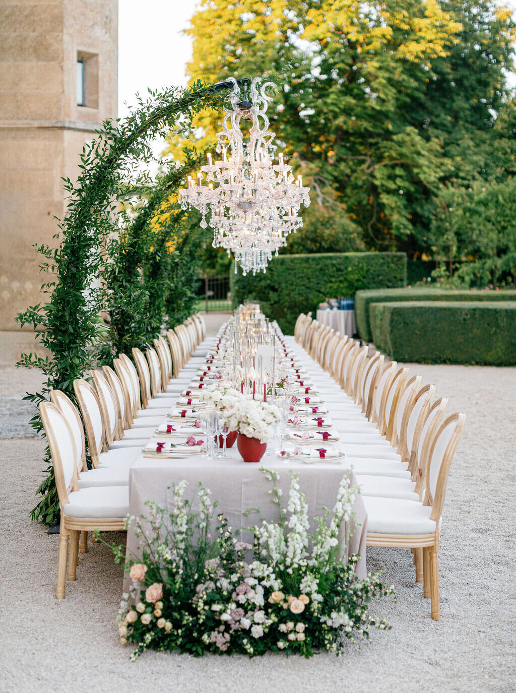 long-wedding-table-under-elegant-chandelier-and-flowers