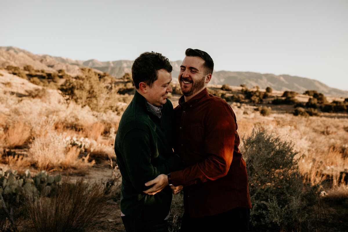 gay couple ticking each other and laughing in the desert