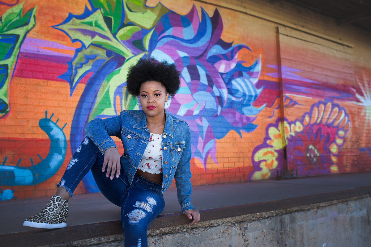 African american with afro sitting against graffiti wall in plainview tx