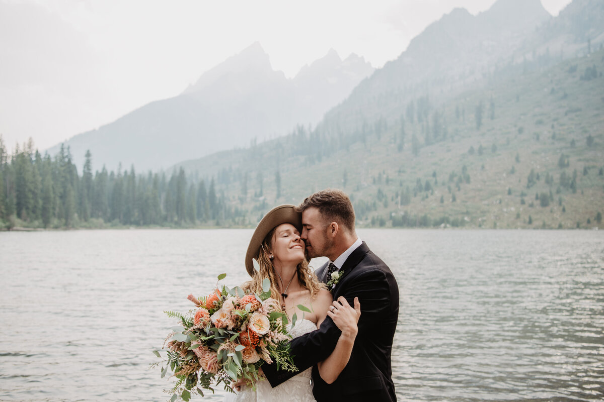 Jackson Hole Photographers capture bride and groom kissing during portraits