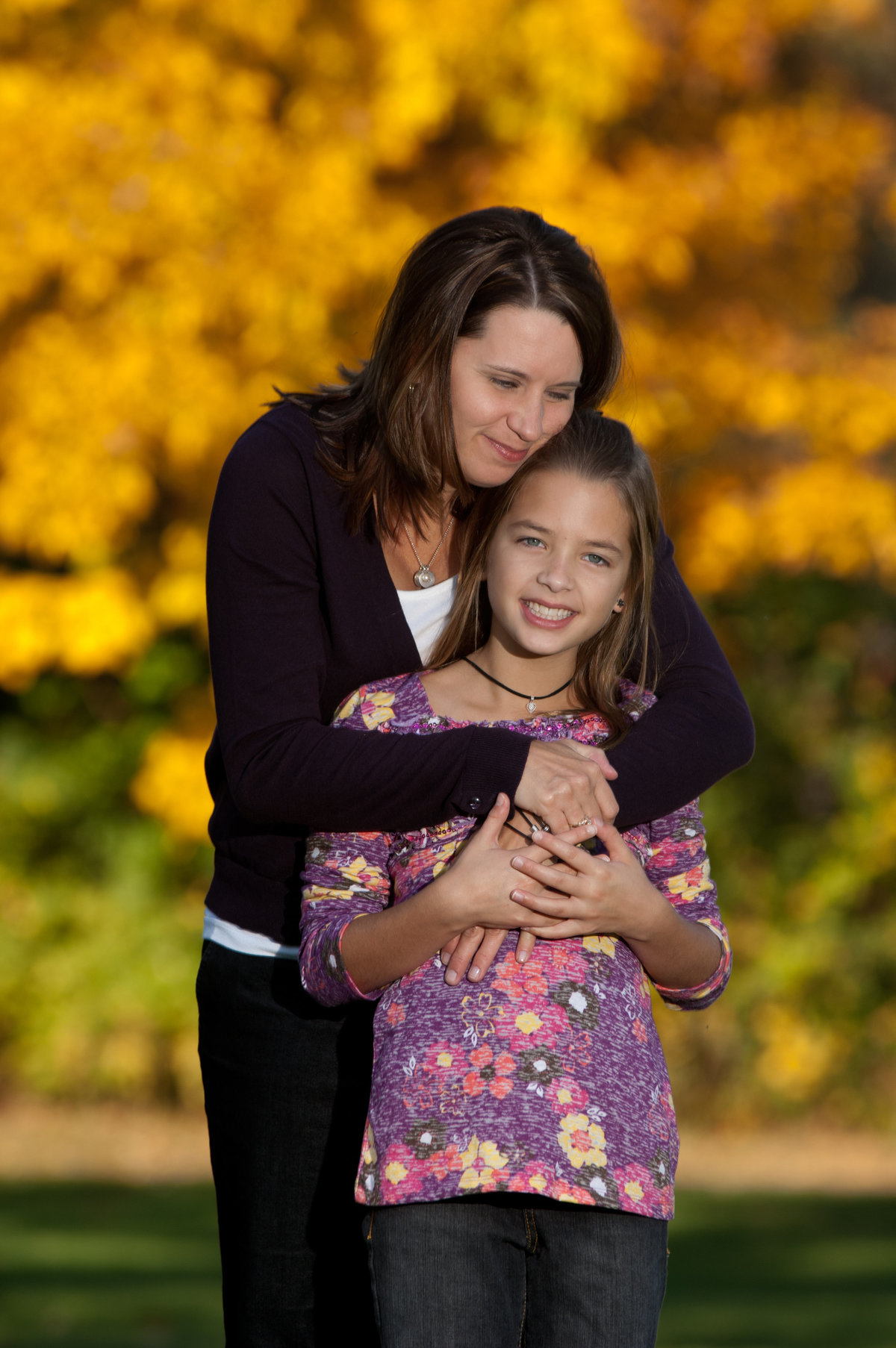 Mom hugging her daughter during a fall family portrait