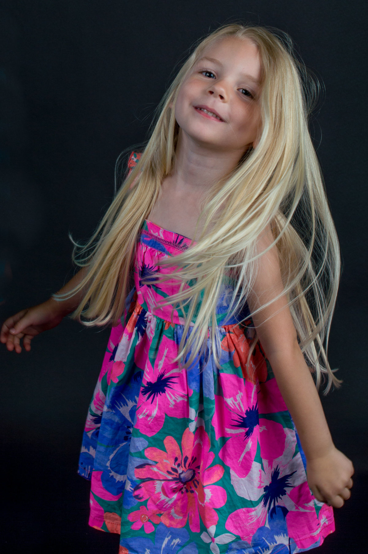 A girl twirls during her studio photo session