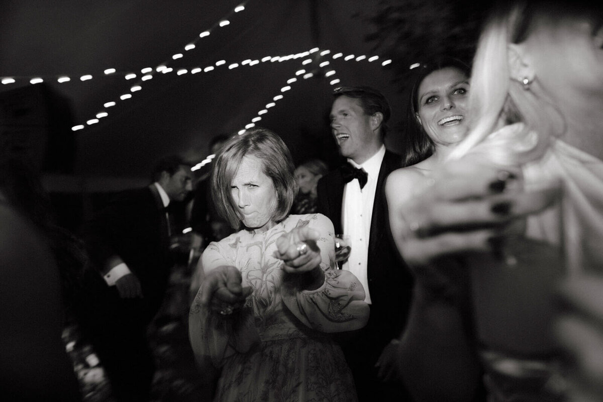 The bride's mom is having a good time partying with the guests in a wedding reception at The Ausable Club, NY. Image by Jenny Fu Studio