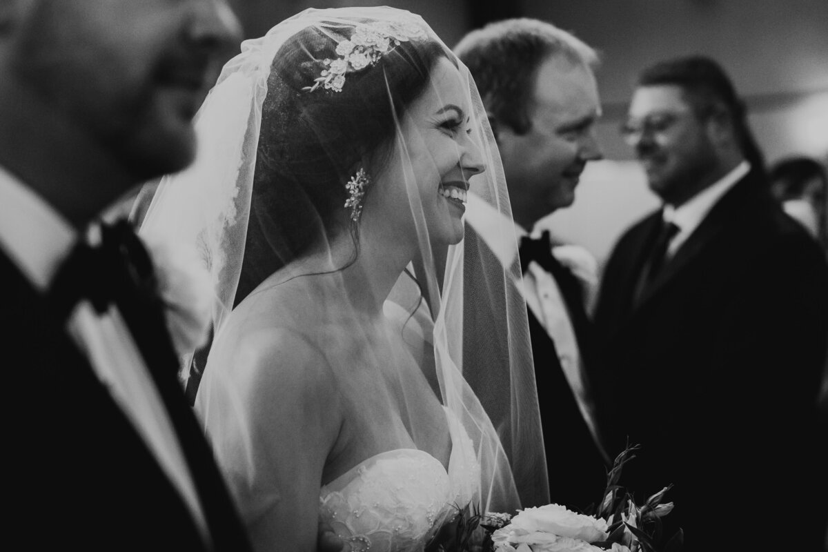 bride walking down aisle with veil and father