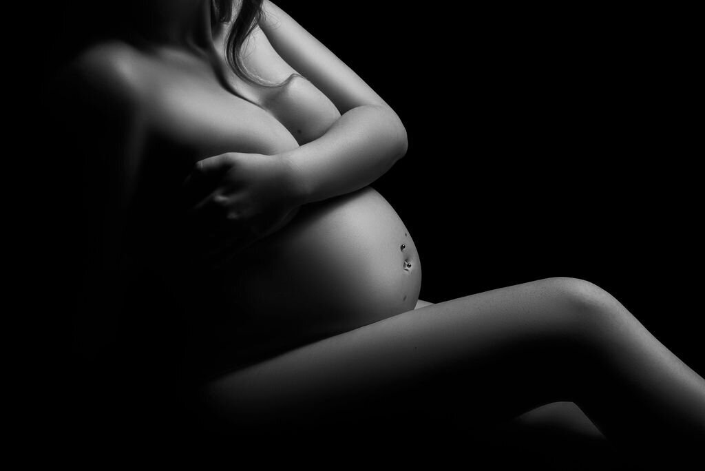 A closeup maternity bodyscape of a pregnant woman in black and white, captured by a photographer in Bemidji, Minnesota