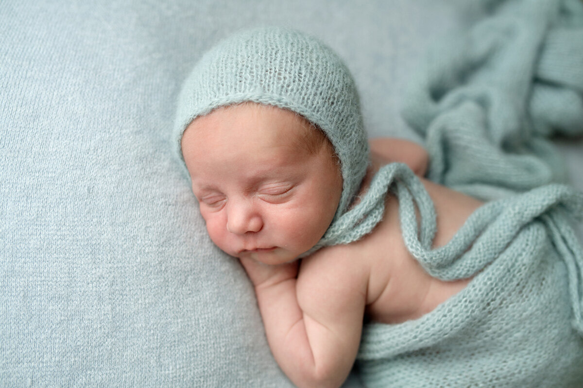 Newborn session of baby wearing a knit hat