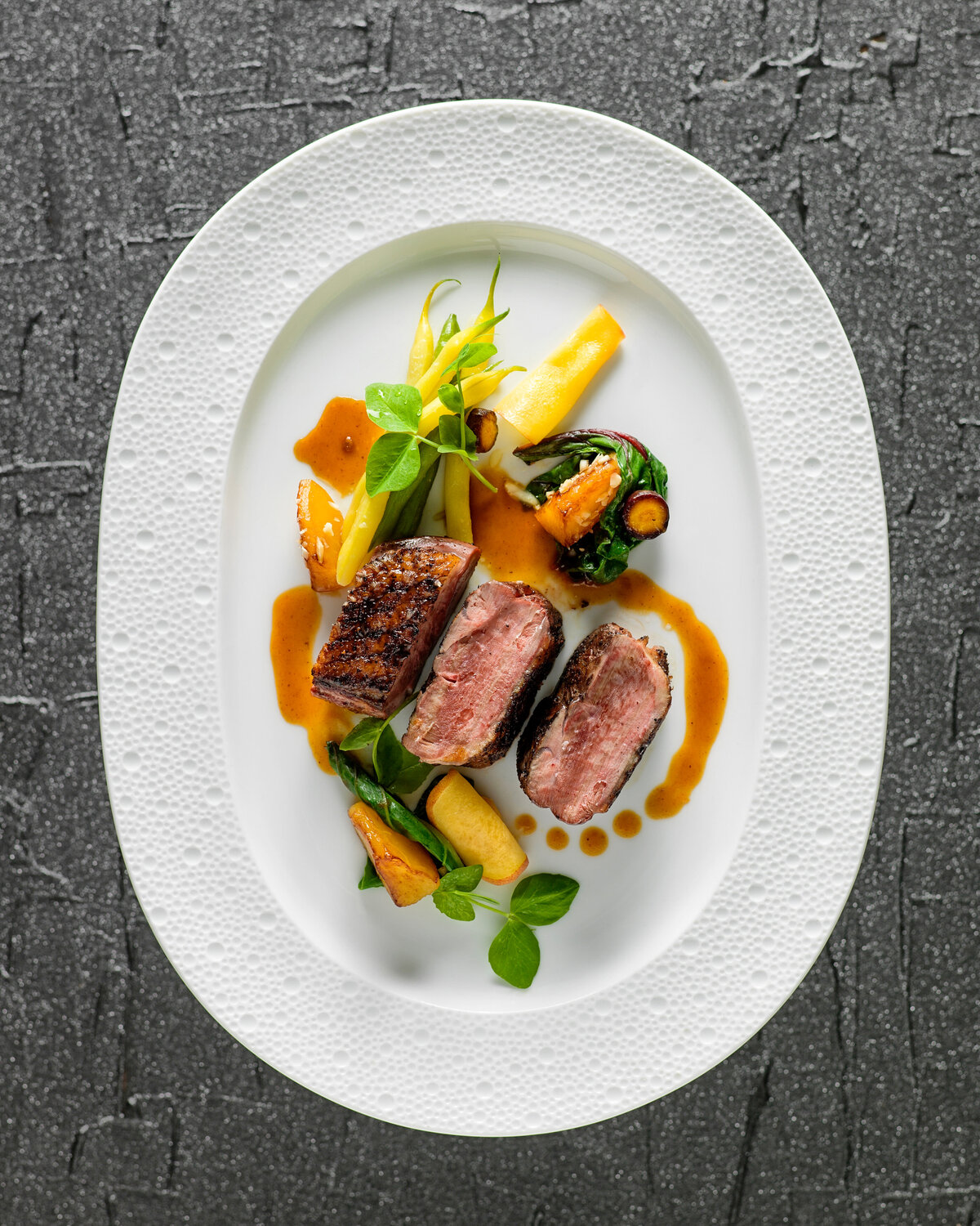 Steak and vegetables neatly plated on a dish