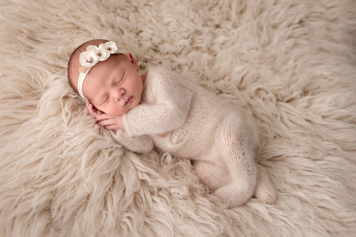 Newborn girl photographed in a cozy  knitted romper