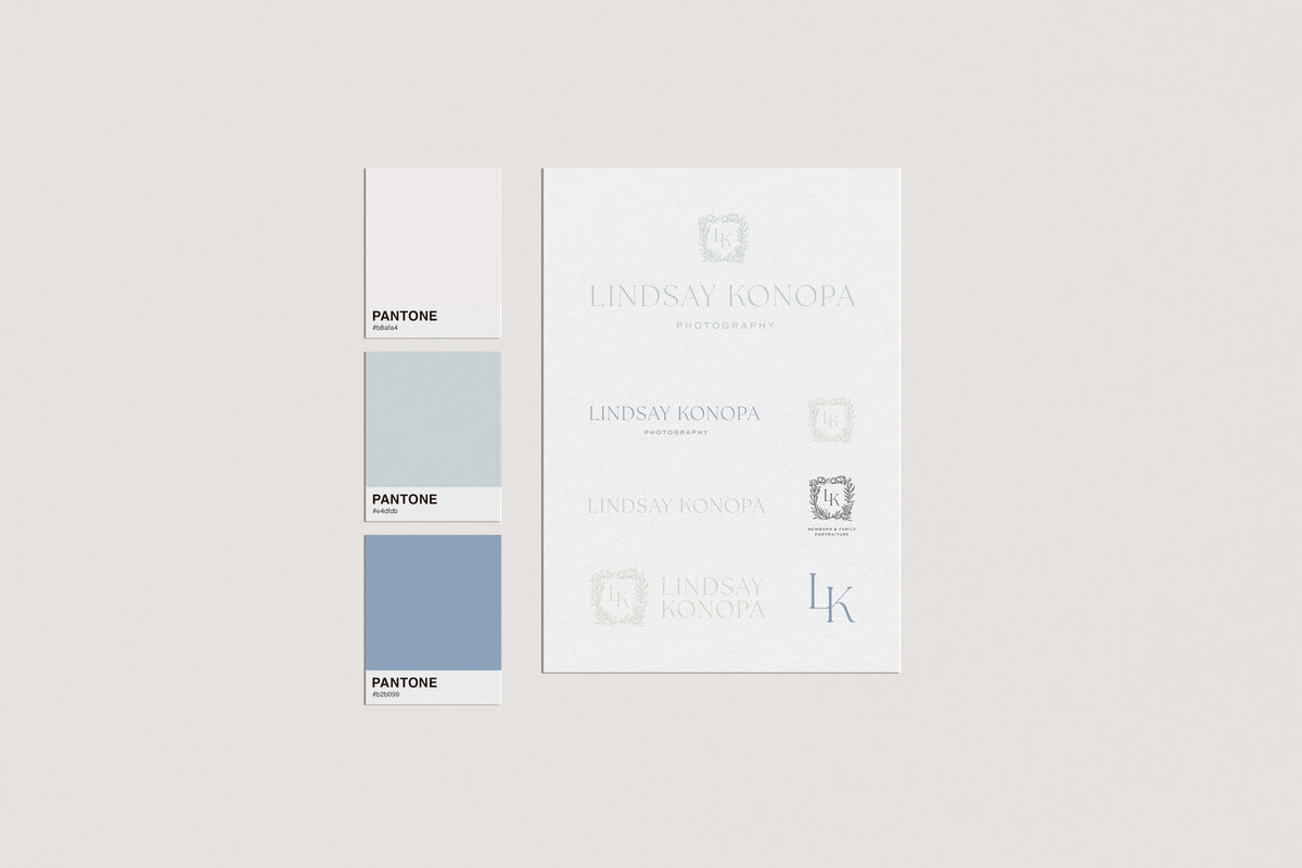 a mockup showing blue and white Pantone chips and a paper with logo designs on it
