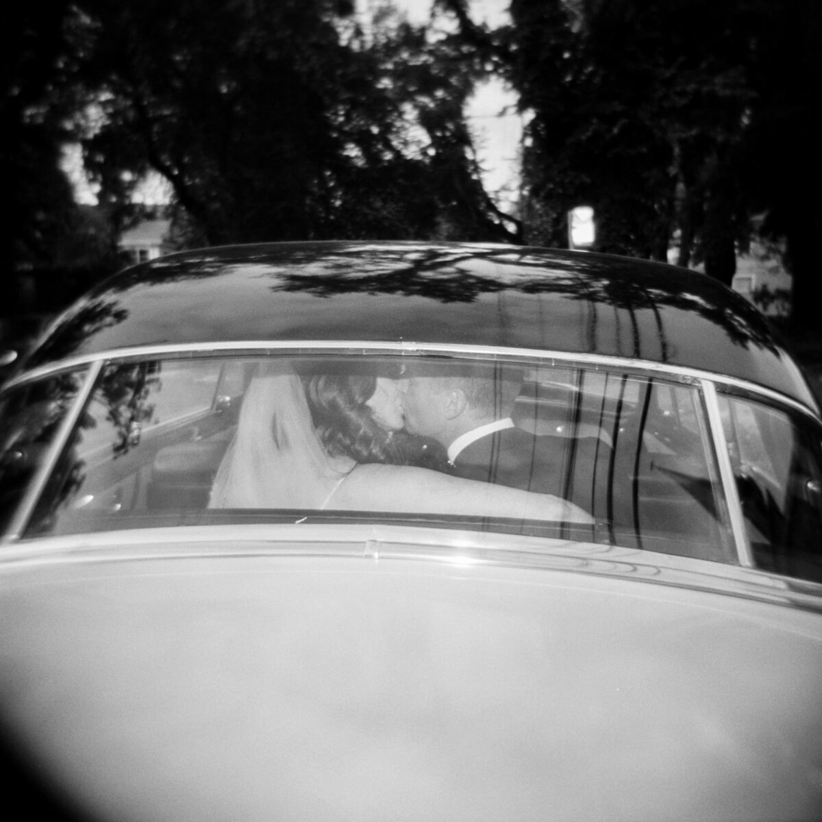 Bride and groom seen in the back window of wedding car at Halifax wedding, Nova Scotia