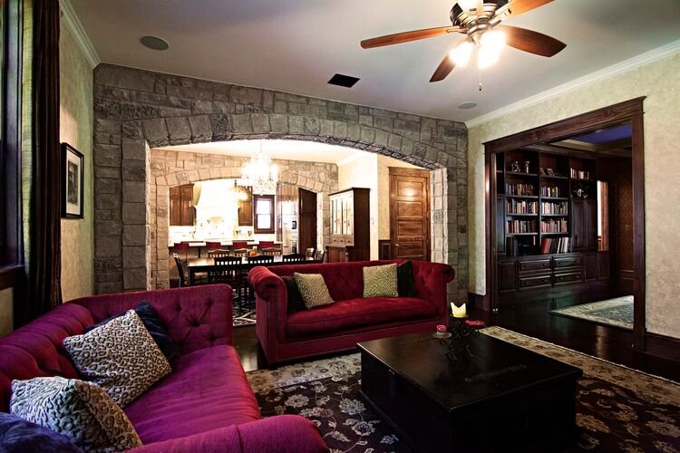 medieval style home with stone accent wall and cranberry colored antique furniture.