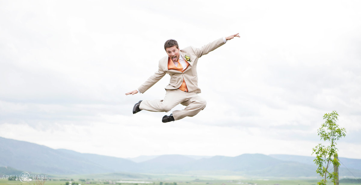 Groom jumps on a trampoline before his Steamboat Springs Colorado backyard wedding during summer