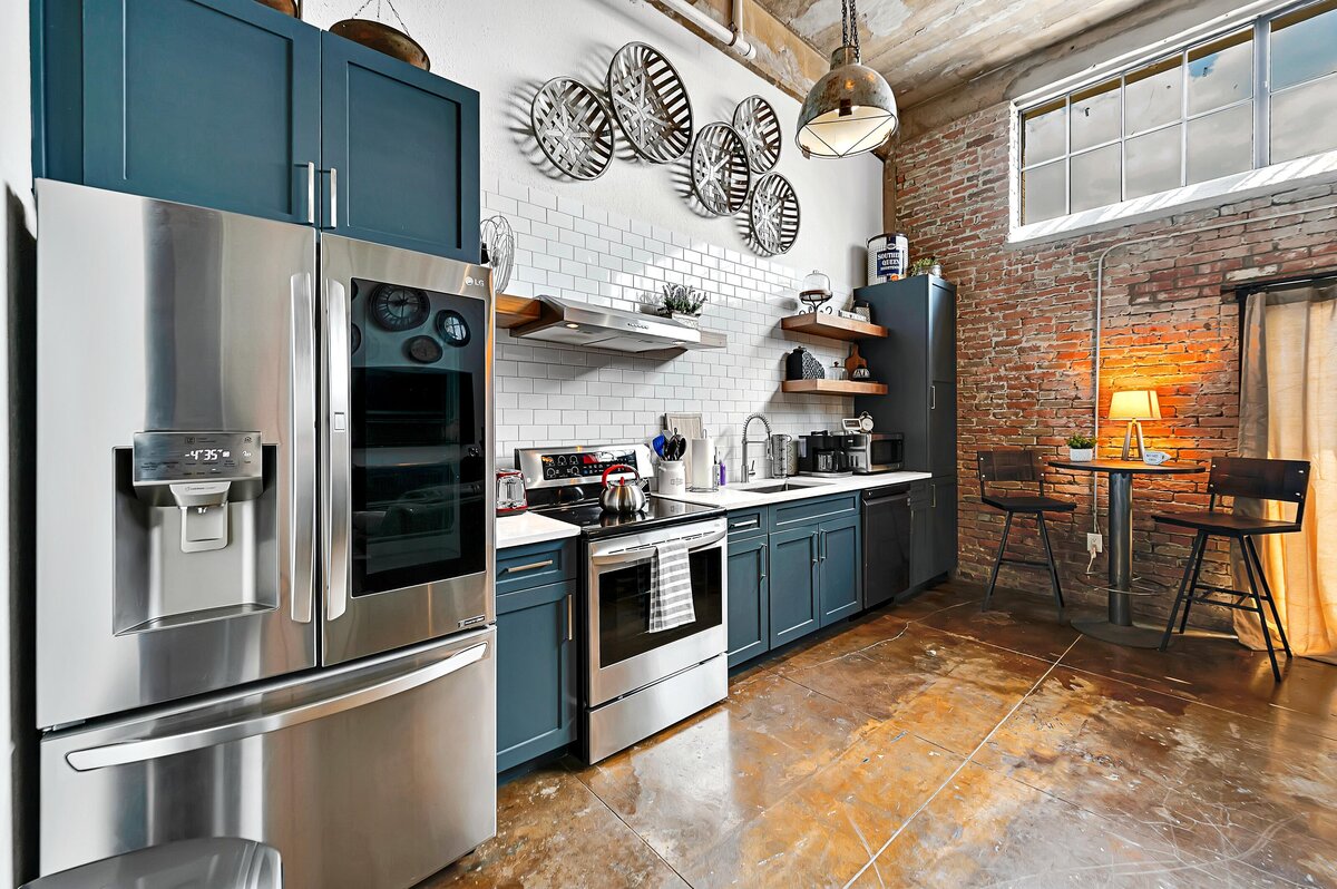 Kitchen with stainless steel appliances at this two-bedroom, two-bathroom vacation rental condo in the historic Behrens building in the heart of the Magnolia Silo District in downtown Waco, TX.