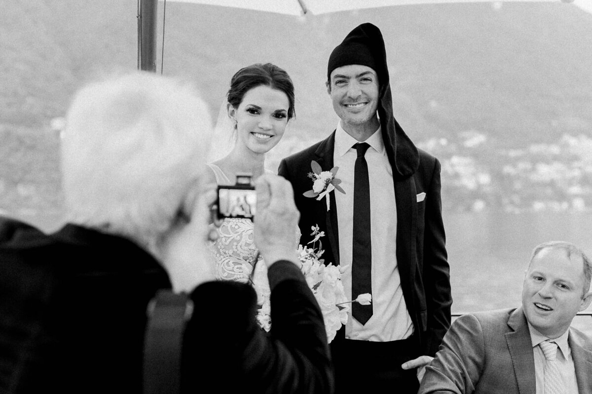 man taking photograph of bride and groom at Italian wedding reception black and white