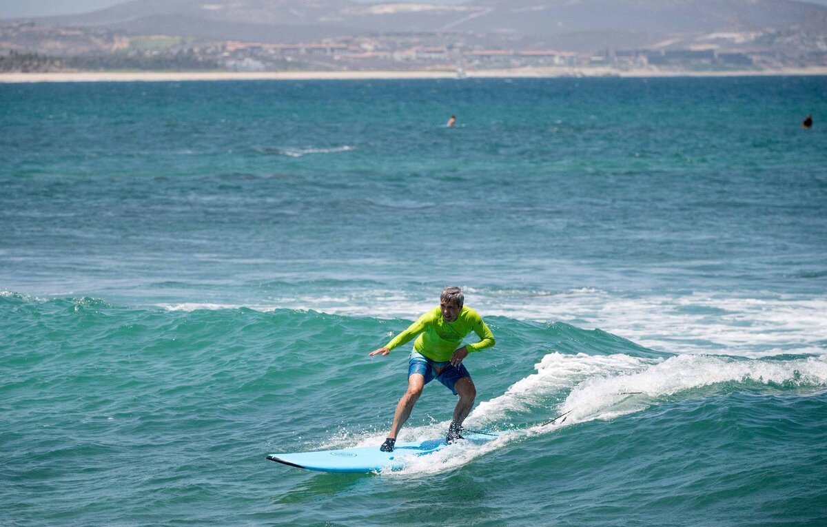 A man surfs a wave at an offsite activity in Baja, Mexico as part of an instructional class.