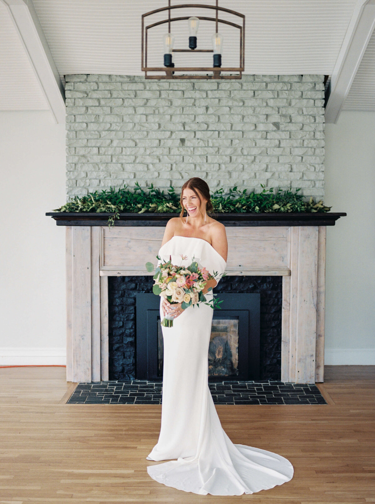 Bride standing in front of fireplace at Oceanstone Resort Wedding in Nova Scotia