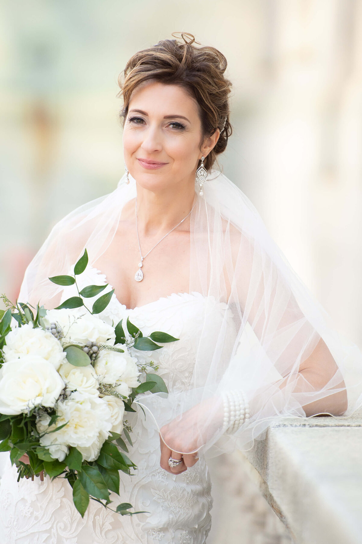 stunning portrait of a mature bride holding her bouquet outside the Chateau Laurier hotel.  Captured by Ottawa wedding photographer JEMMAN Photography