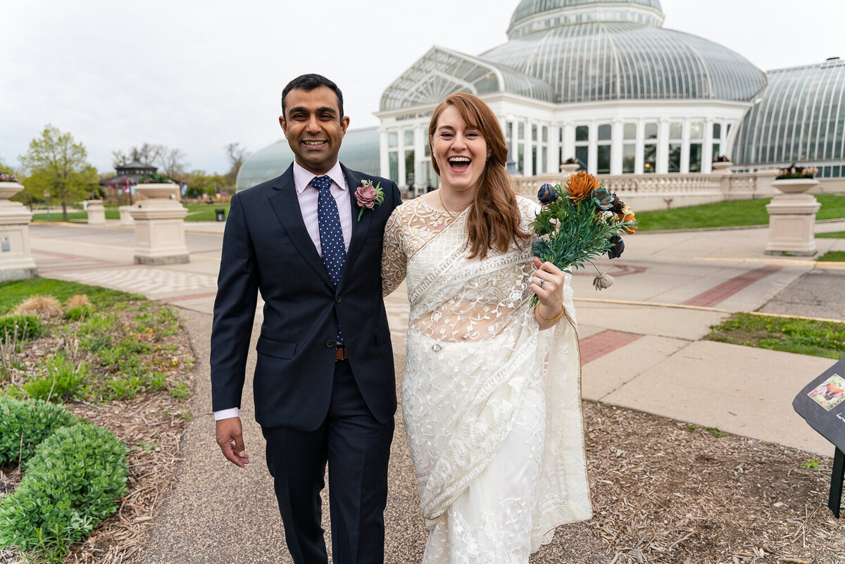 Indian groom and bride laugh in front of  Como Zoo Conservatory.