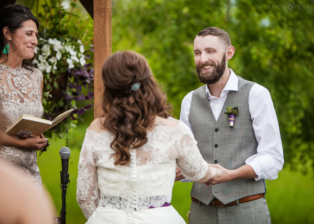 Groom smiles at bride at their outdoor wedding at Denver Botanic Gardens Chatfield Farms