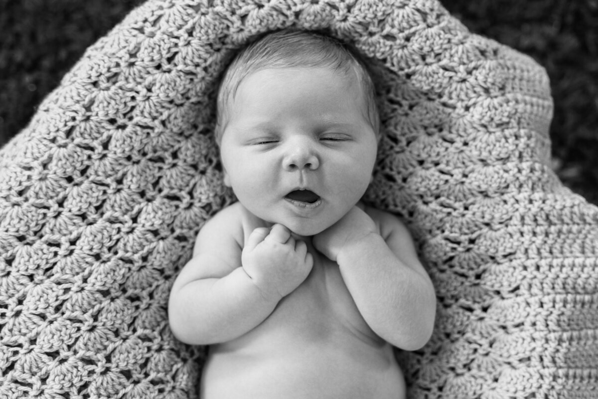 newborn baby on knit blanket
