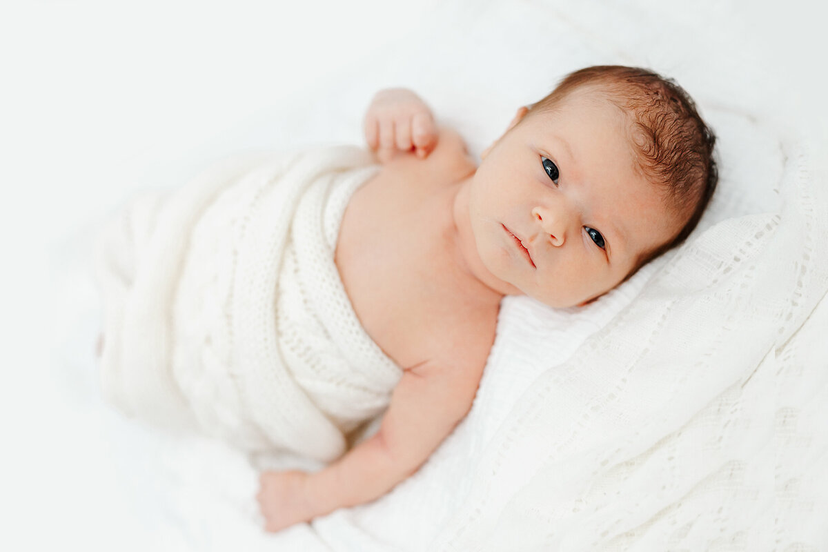 newborn wrapped in a white blanket