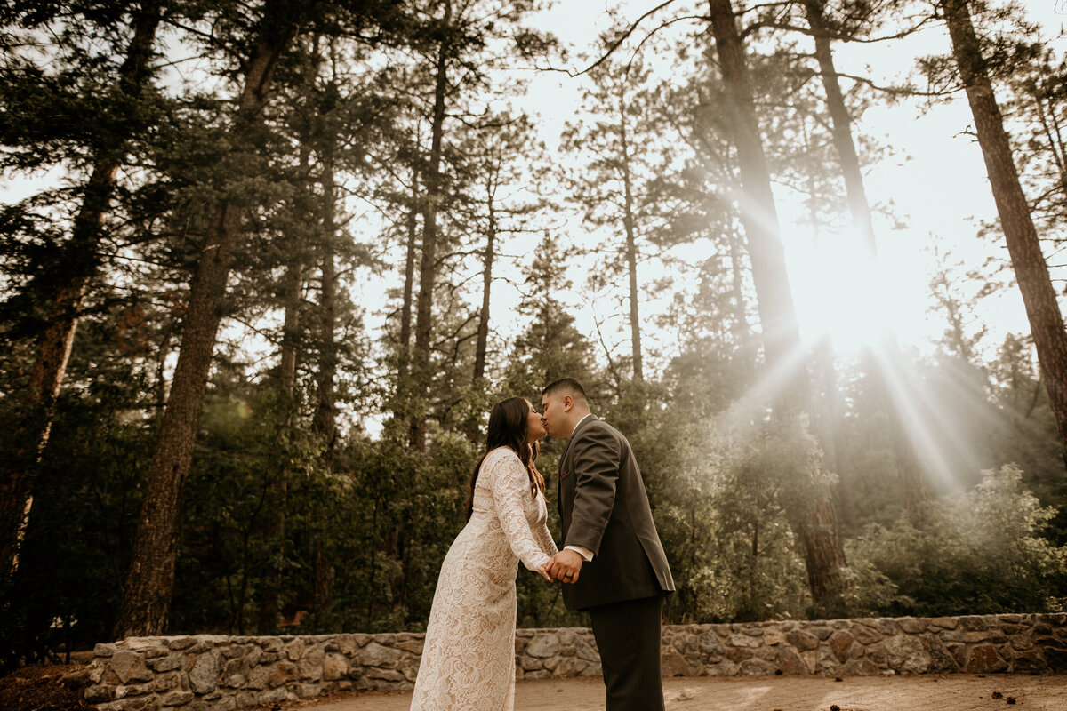 bride and groom kissing in the forest in New Mexico