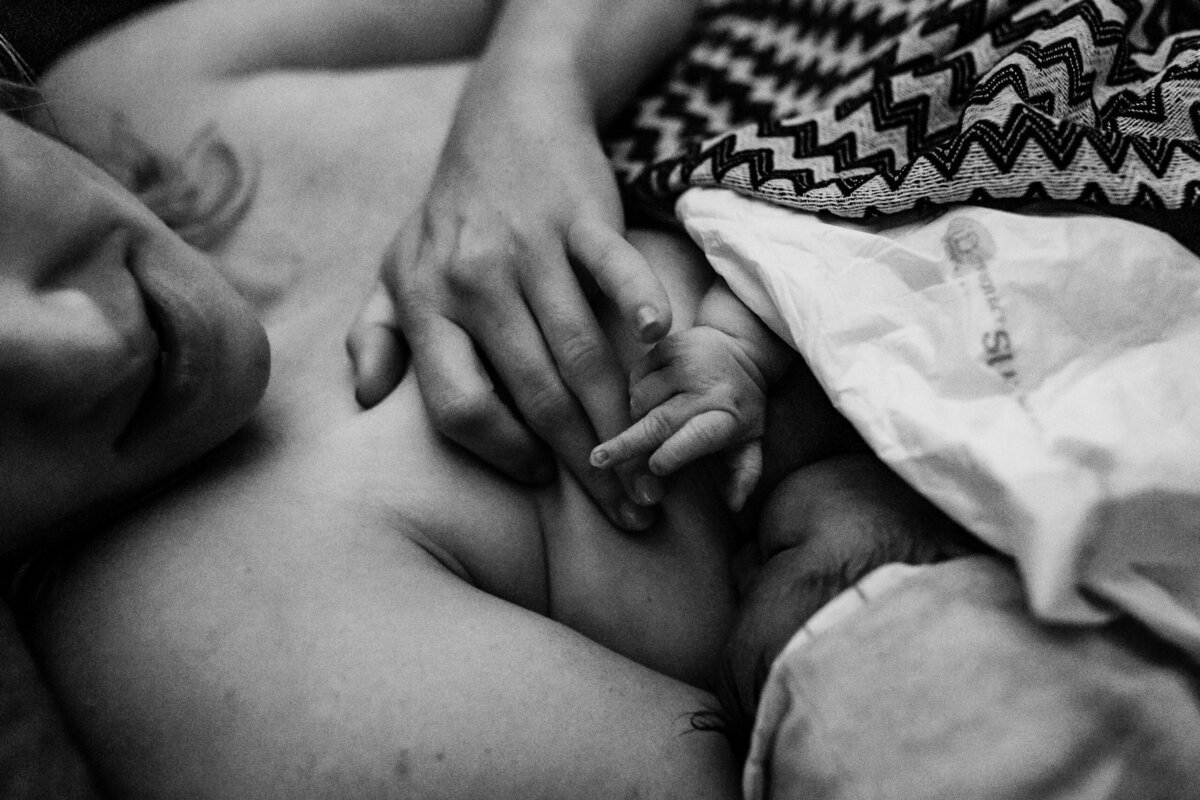 zwart wit foto van moederhand en babyhandje