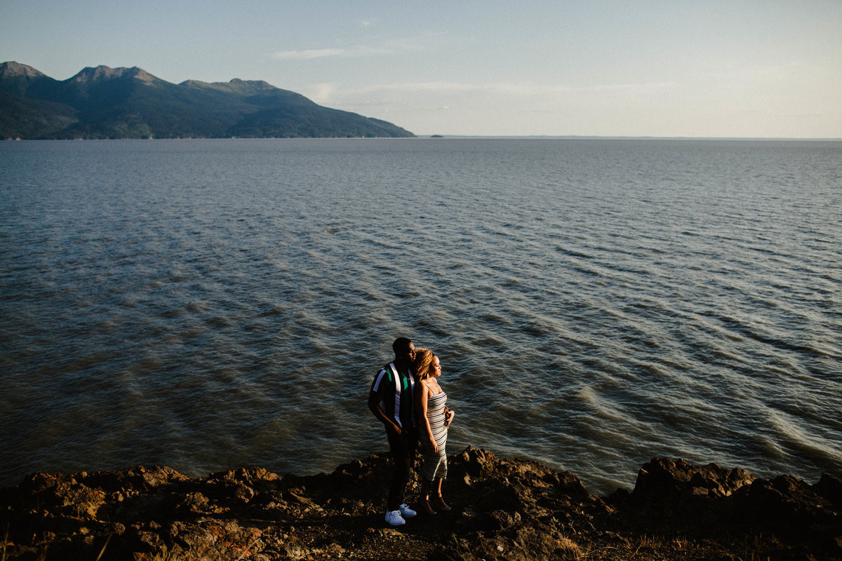 wide shot of couple along turnagain arm with view of the ocean