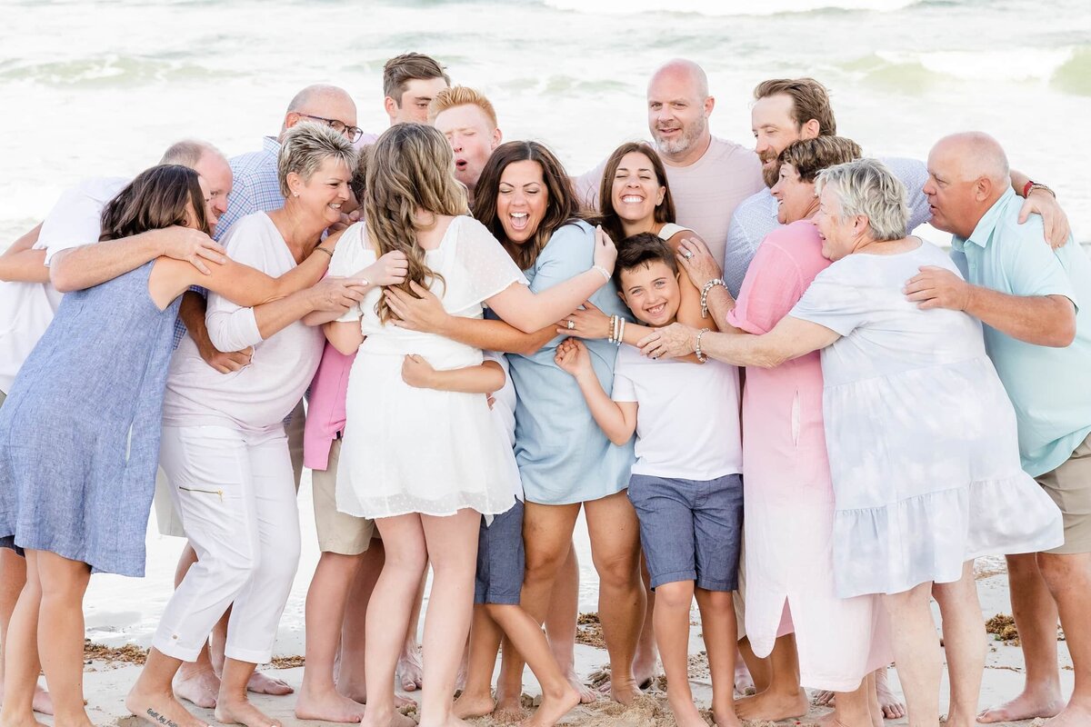 Extended family hugging at the beach