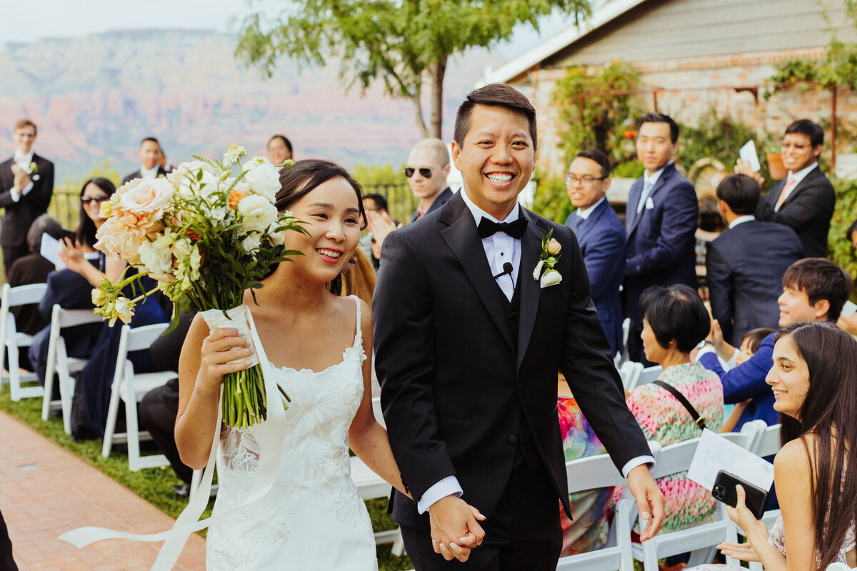 bride and groom walk down the isle after their wedding ceremony in sedona