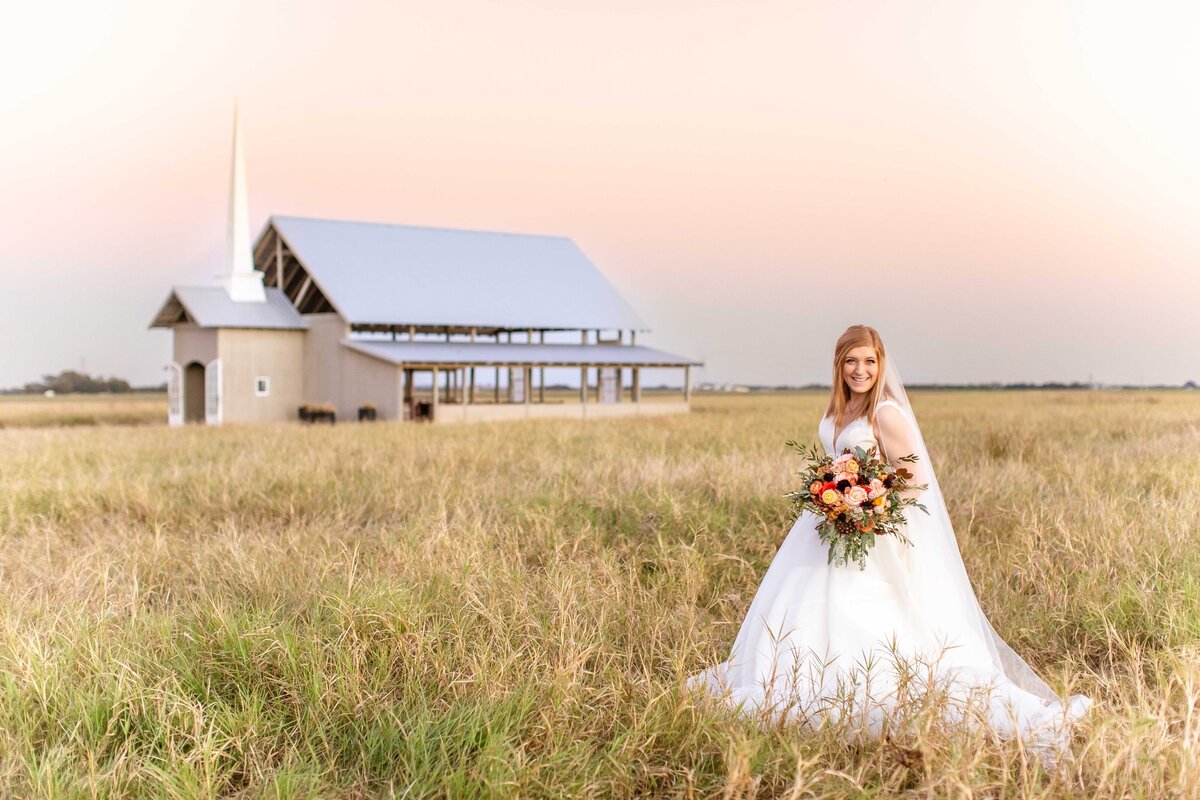Allen Farmhaus chapel with bride at sunset holding Fall bouquet New Braunfels Texas