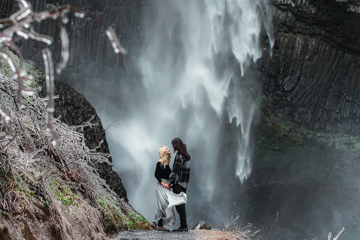 engaged couple at frozen waterfall
