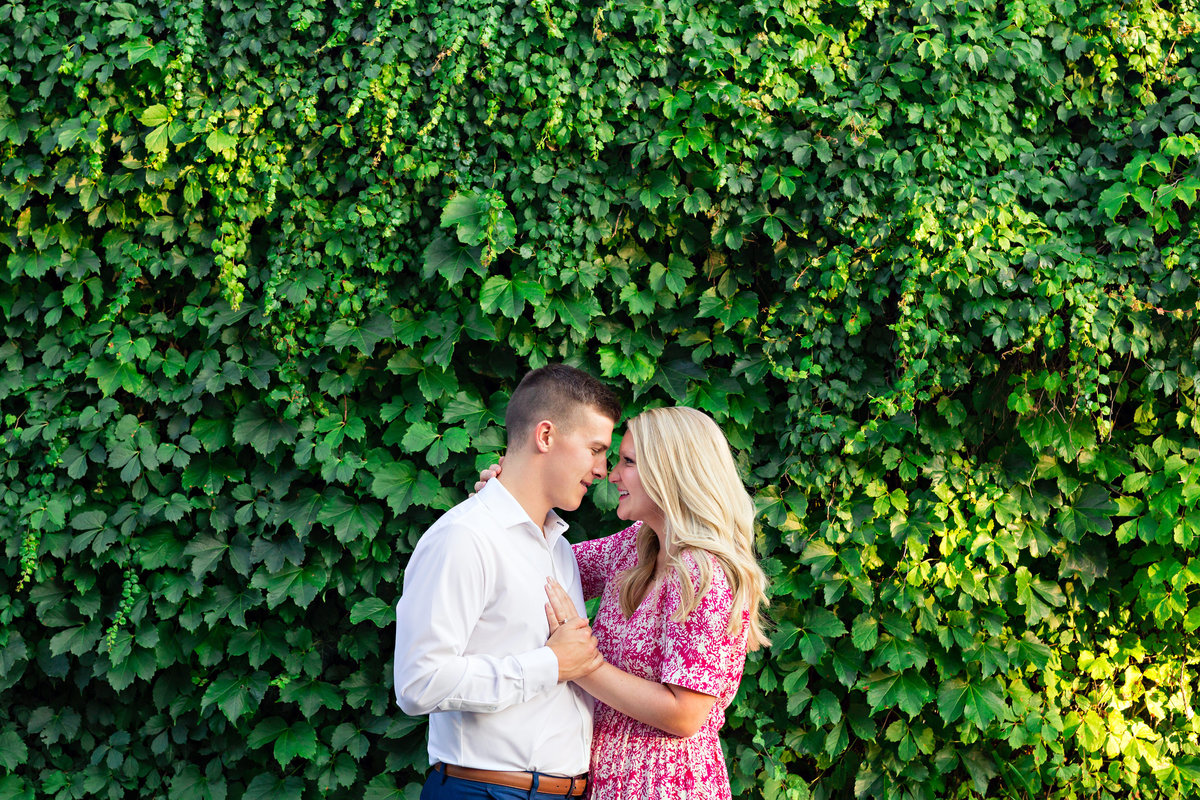 The couple hold each other close in front of the ivy wall in Portsmouth NH
