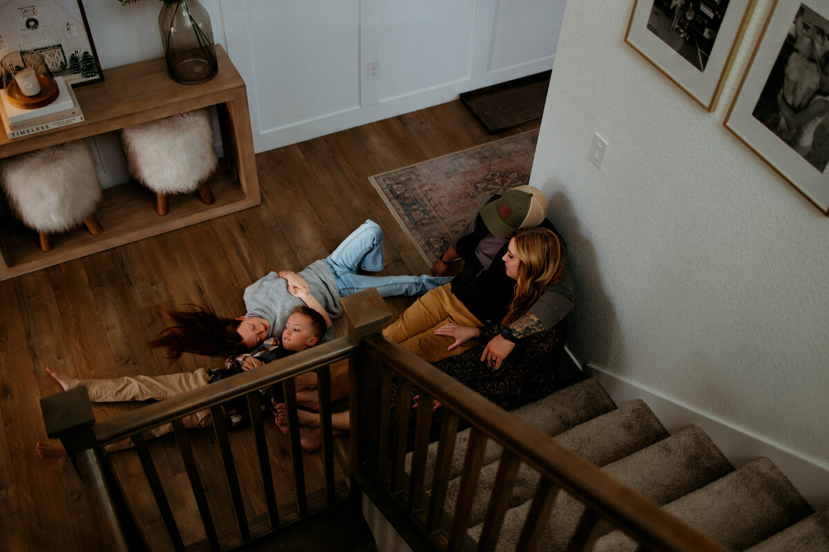 family cuddled near bottom of stairs for family photos