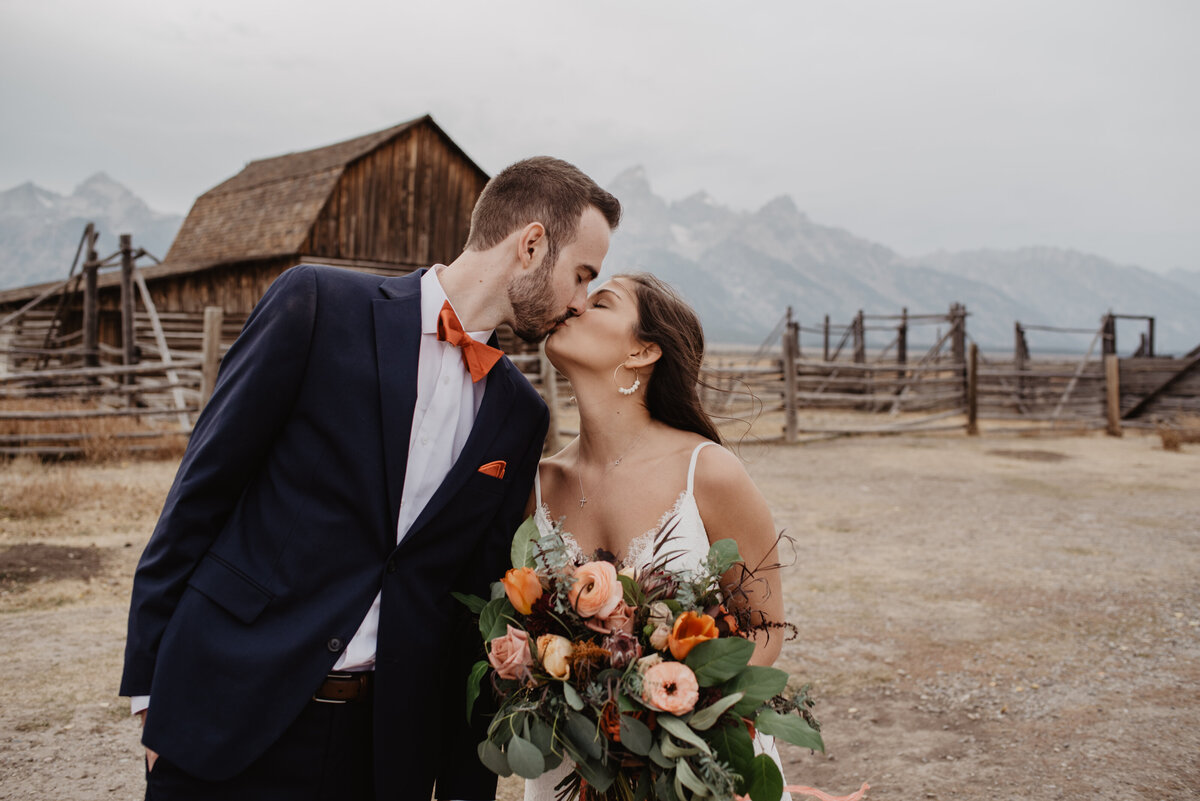 Photographers Jackson Hole capture bride and groom kissing during bridal portraits
