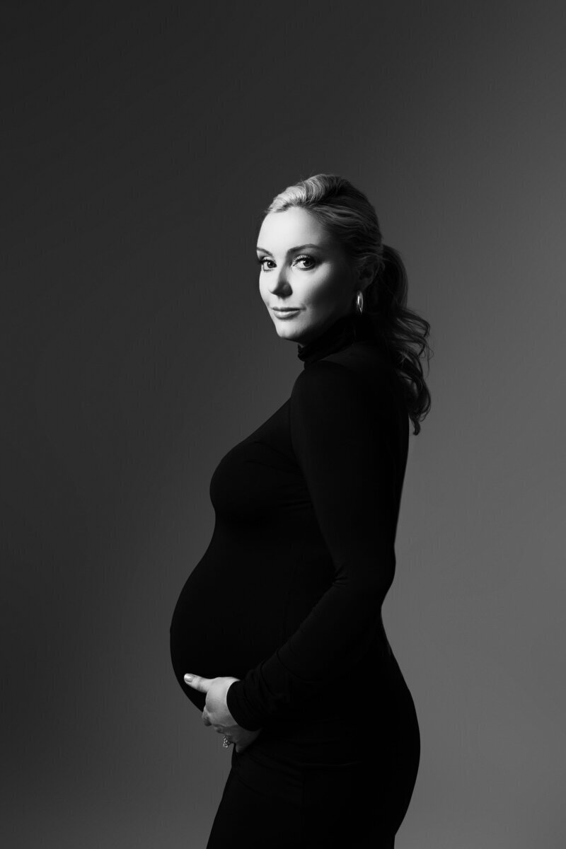 Expecting mom side profile of bump in black dress by maternity photographer new jersey