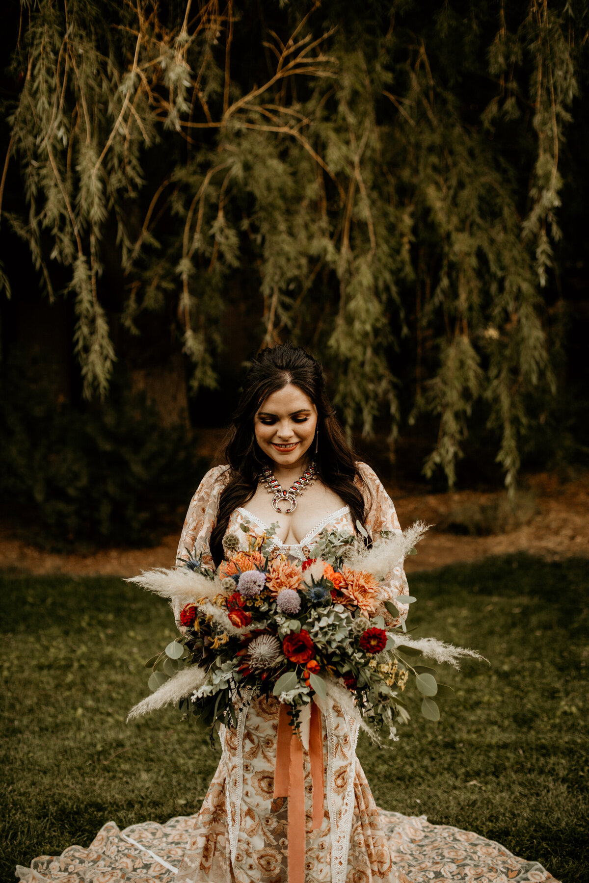 bride standing in her peach lace wedding dress and New Mexico jerelry