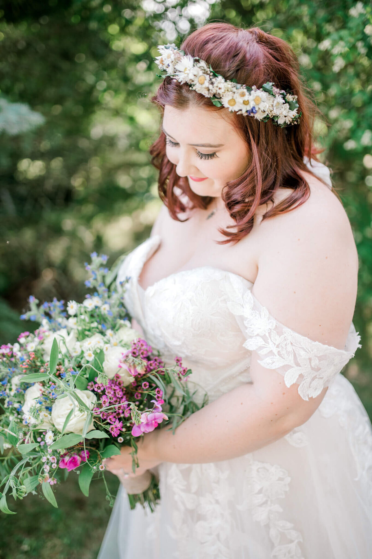 Bride holding bouquet while looking down at them