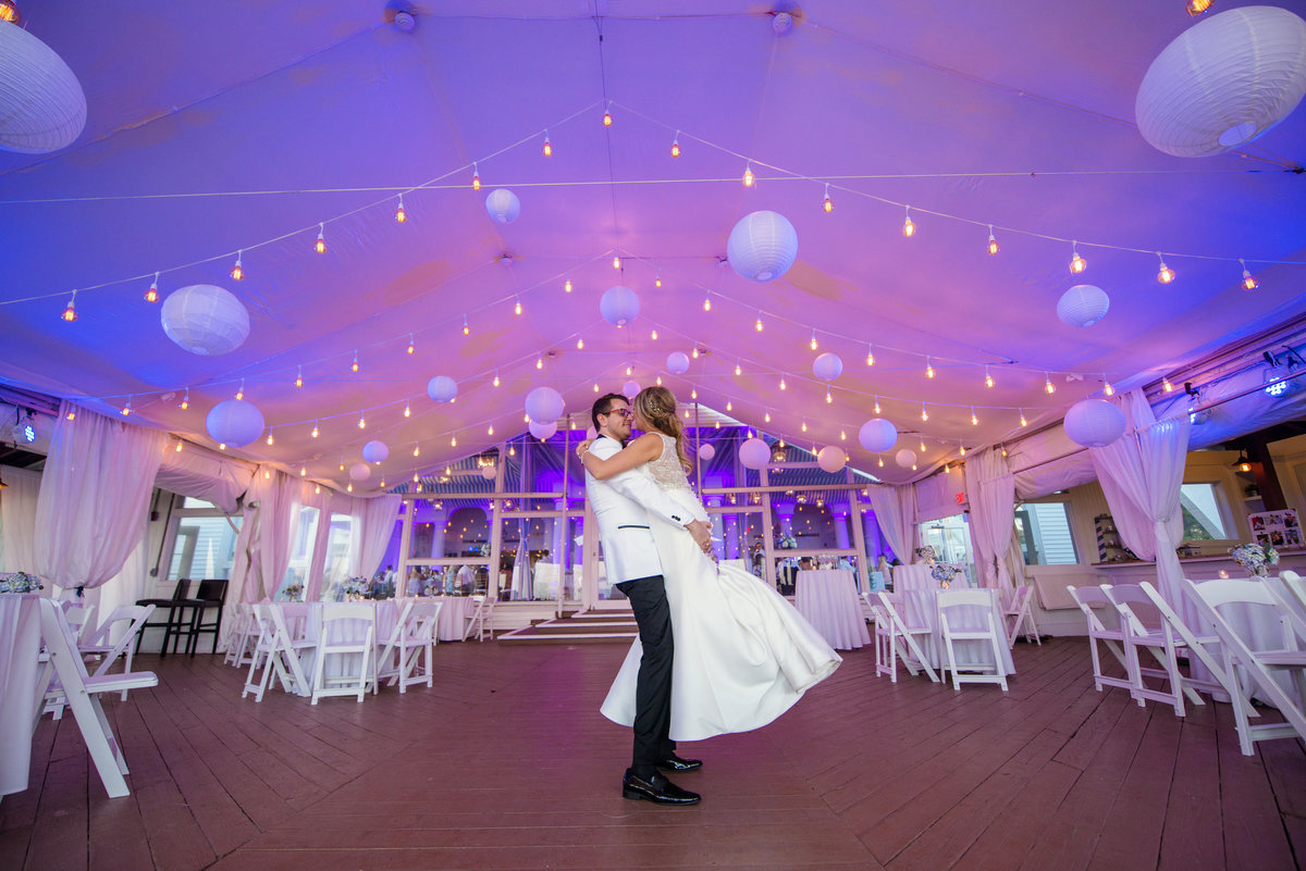Groom lifting bride at the ballroom of Oceanbleu