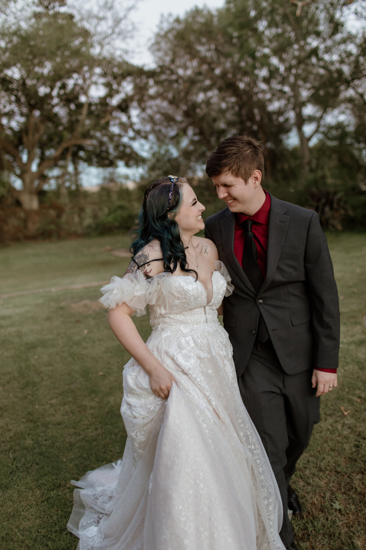 A bride and groom take a romantic sunset walk at Weston Gardens in Bloom in Fort Worth Texas. Captured by Fort Worth Wedding Photographer, Megan Christine Studio