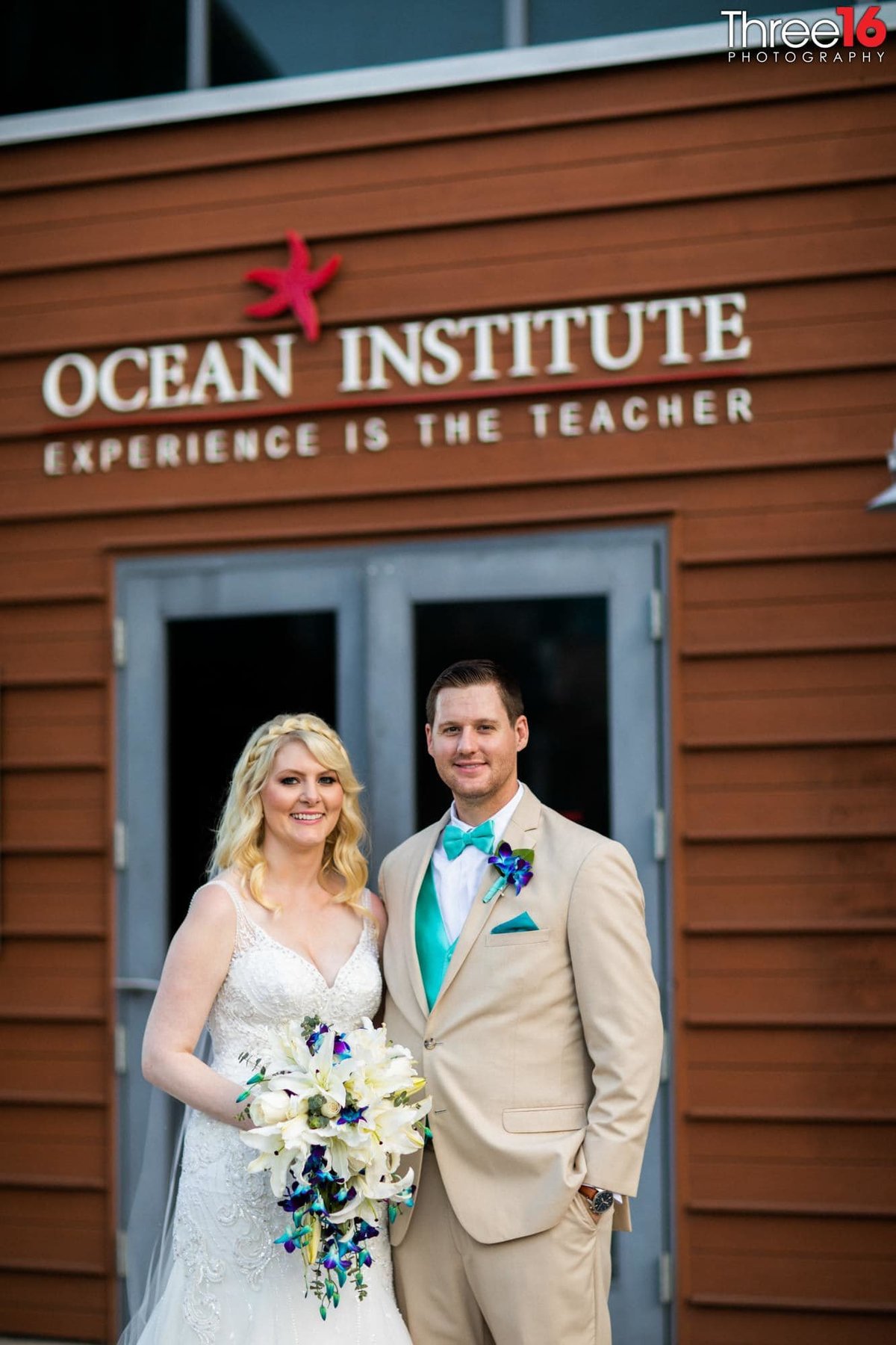 Bride and Groom pose for photos in front of the Ocean Institute wedding venue